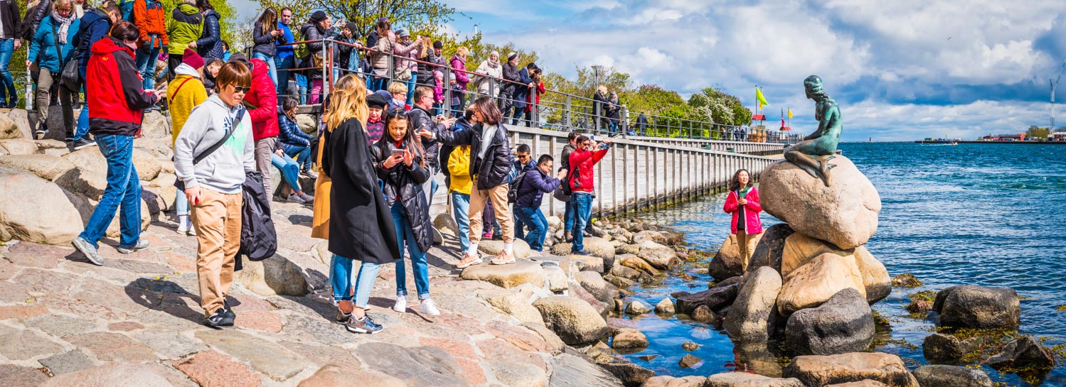 Copenhagen harbour panorama crowds of tourists visiting Little Mermaid Statue Denmark